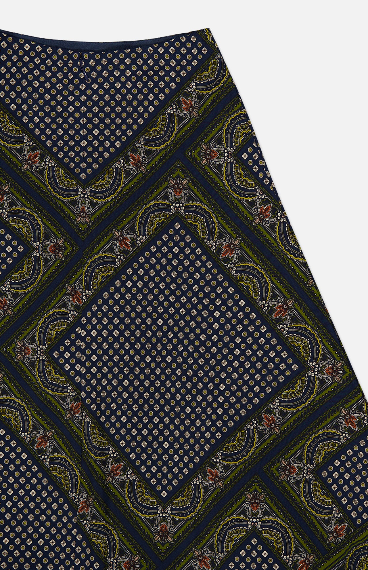 The Hartley Scarf Print Skirt by VERONICA BEARD showcases a dark fabric adorned with a repeating geometric and paisley-inspired motif: small circles nestled within diamond shapes, bordered by intricate curved patterns in navy, gold, olive, and subtle accents of red—an eye-catching design perfect for an elegant silk midi skirt.