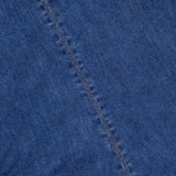 Close-up of the Imara Denim Mini Dress by VERONICA BEARD, highlighting blue denim fabric with a diagonal seam, visible stitching, and textured weave.
