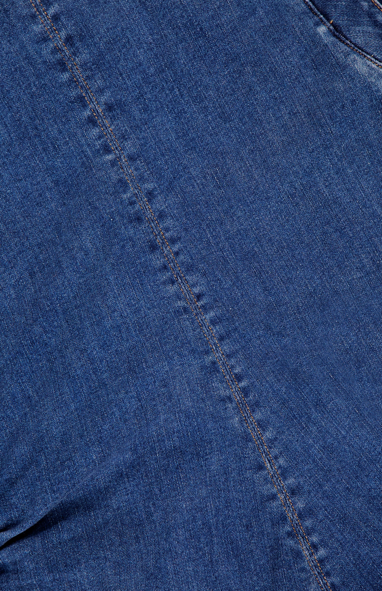 Close-up of the Imara Denim Mini Dress by VERONICA BEARD, highlighting blue denim fabric with a diagonal seam, visible stitching, and textured weave.