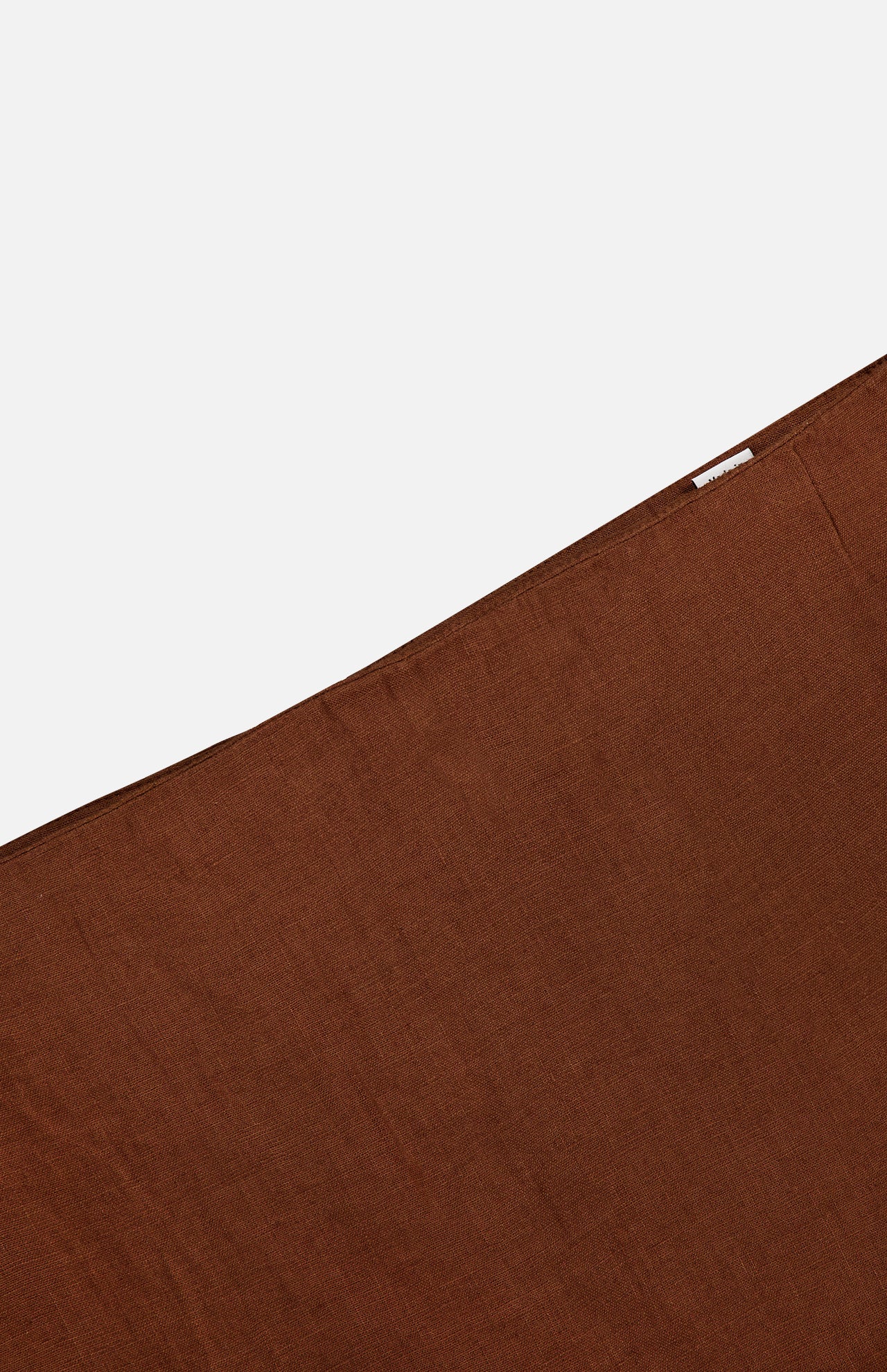 A close-up of the VERONICA BEARD Malou Embroidered Midi Skirt in brown linen with a diagonal edge and a small white label near the top right corner, set against a plain white background.
