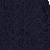 Close-up of the Massimo Stretch Midi Skirt by VERONICA BEARD in navy cotton lace, featuring a textured floral pattern. This versatile skirt is shown against a white background and suits both office and evening wear.