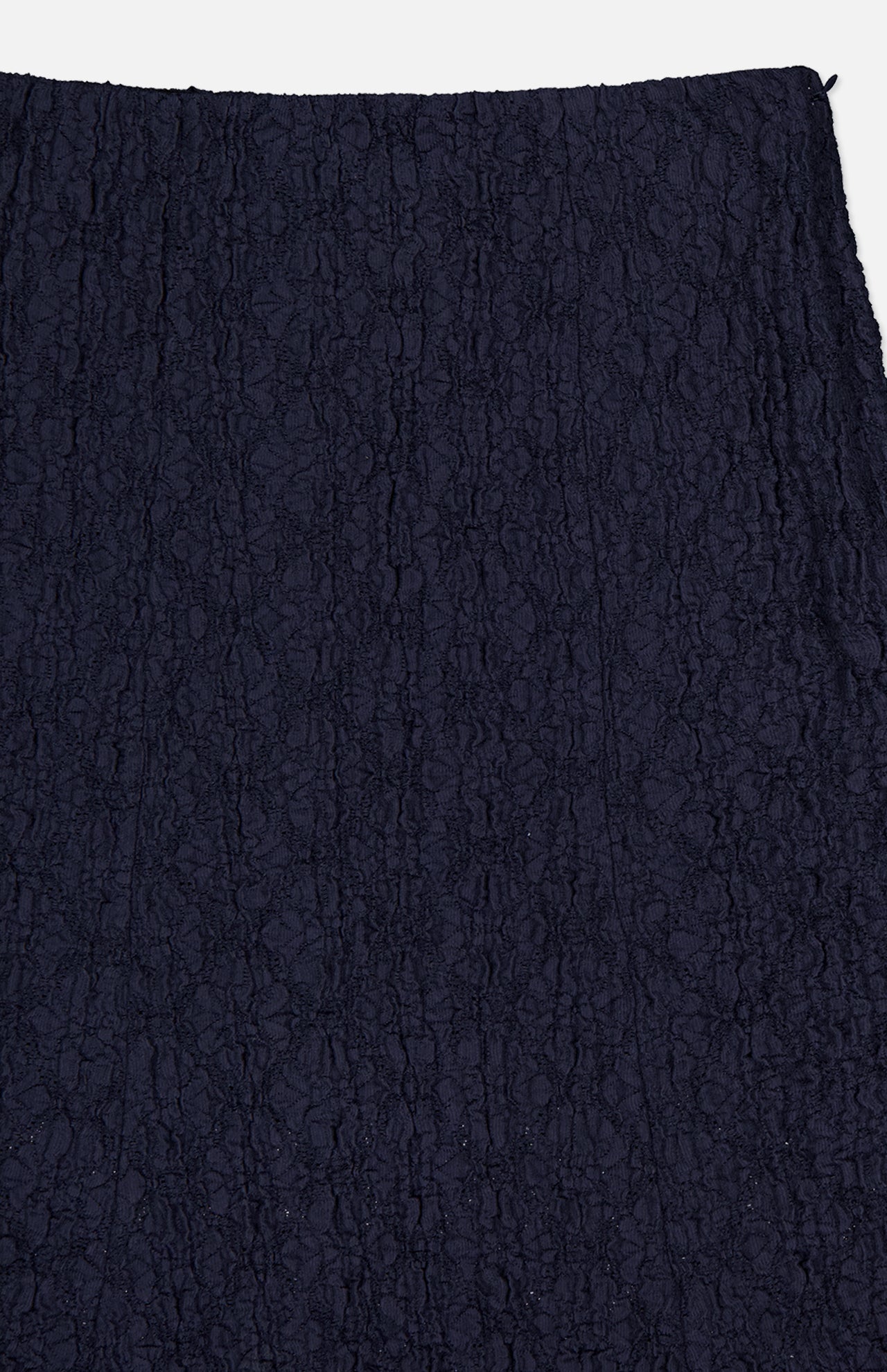 Close-up of the Massimo Stretch Midi Skirt by VERONICA BEARD in navy cotton lace, featuring a textured floral pattern. This versatile skirt is shown against a white background and suits both office and evening wear.