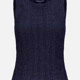 The Selah Sleeveless Stretch Tank by VERONICA BEARD is a fitted navy tank with a round neckline, crinkled texture, and delicate cotton lace details for added style.