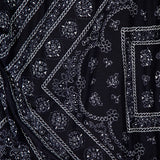 The Sylviani Bandana-inspired Midi Dress by VERONICA BEARD showcases black fabric with a detailed white paisley and floral pattern, featuring diagonal lines, small flowers, and geometric shapes—a perfect pick for bandana motif lovers.