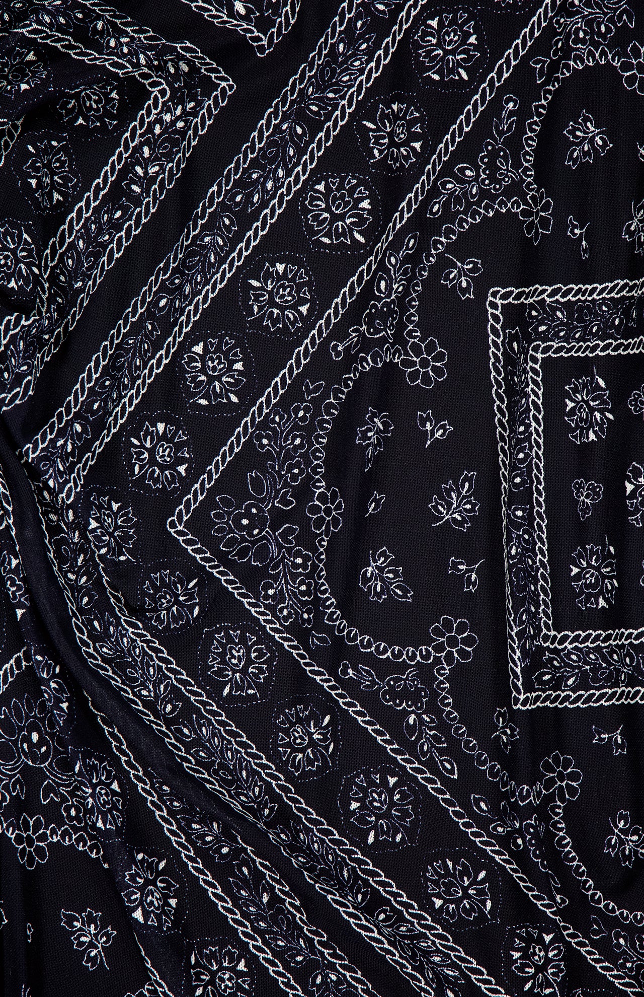 The Sylviani Bandana-inspired Midi Dress by VERONICA BEARD showcases black fabric with a detailed white paisley and floral pattern, featuring diagonal lines, small flowers, and geometric shapes—a perfect pick for bandana motif lovers.