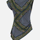 The Yvonne Scarf Print Top by VERONICA BEARD features asymmetrical short sleeves and a vibrant mix of blue, green, and yellow geometric and floral patterns. The draped fabric is ruched on one side for a distinctive gathered look. Shown from the back against a white background.
