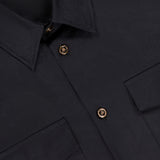 Close-up of the black VERSACE Baroque Jacquard Poplin Shirt with gold Medusa buttons, two flap chest pockets, fine stitching, and signature Barocco pattern accents emphasizing its luxurious details.
