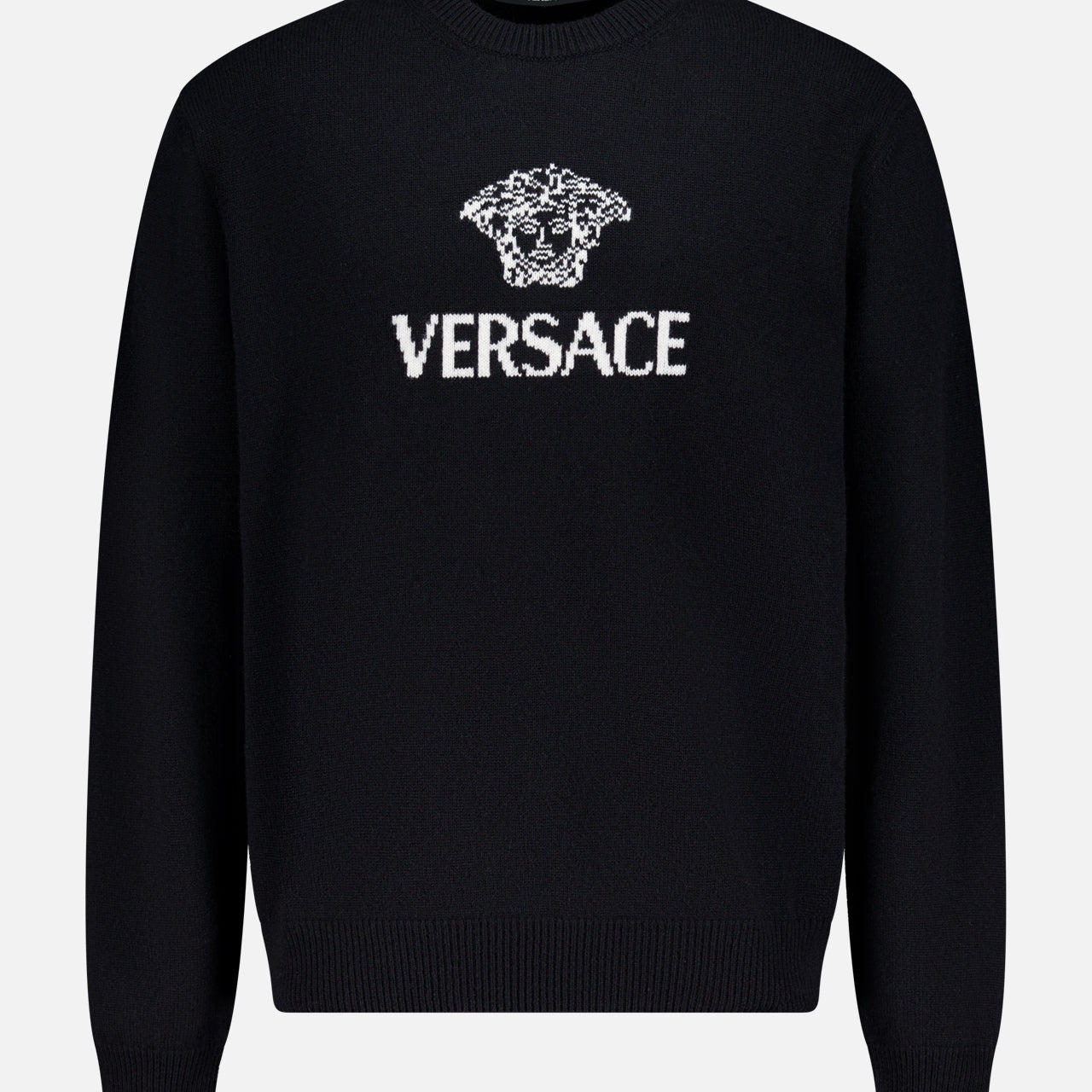 The Medusa Cashmere Knit Sweater by VERSACE is a black crewneck with long sleeves, showcasing the iconic Medusa logo and bold white VERSACE branding on the front—a standout in luxury Italian menswear.