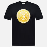 Introducing the VERSACE Cotton Medusa Coin Jersey T-Shirt: a black tee adorned with a striking gold Medusa coin emblem at the center and subtle yellow “VERSACE” lettering below—an iconic example of luxury Italian men’s fashion.