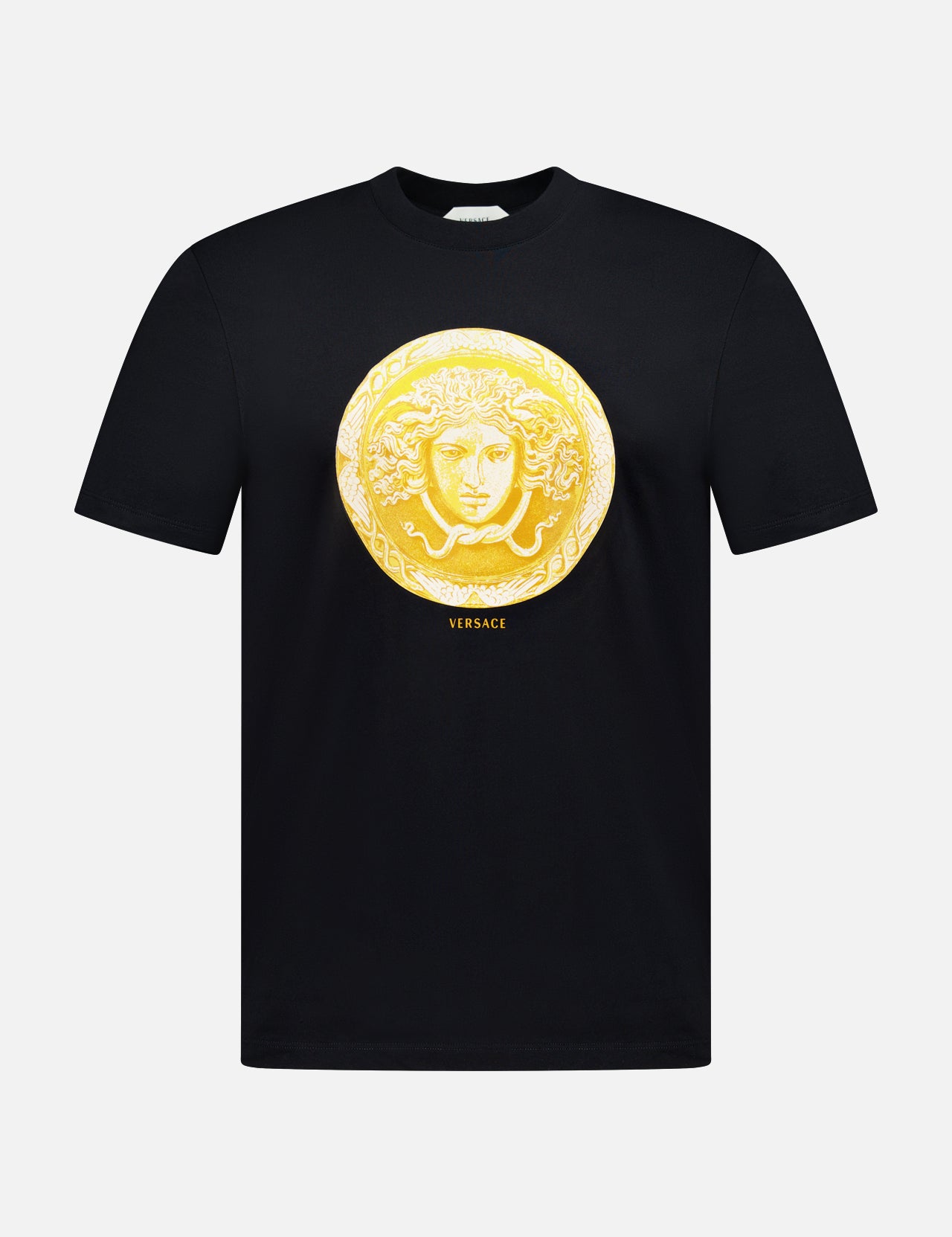 Introducing the VERSACE Cotton Medusa Coin Jersey T-Shirt: a black tee adorned with a striking gold Medusa coin emblem at the center and subtle yellow “VERSACE” lettering below—an iconic example of luxury Italian men’s fashion.