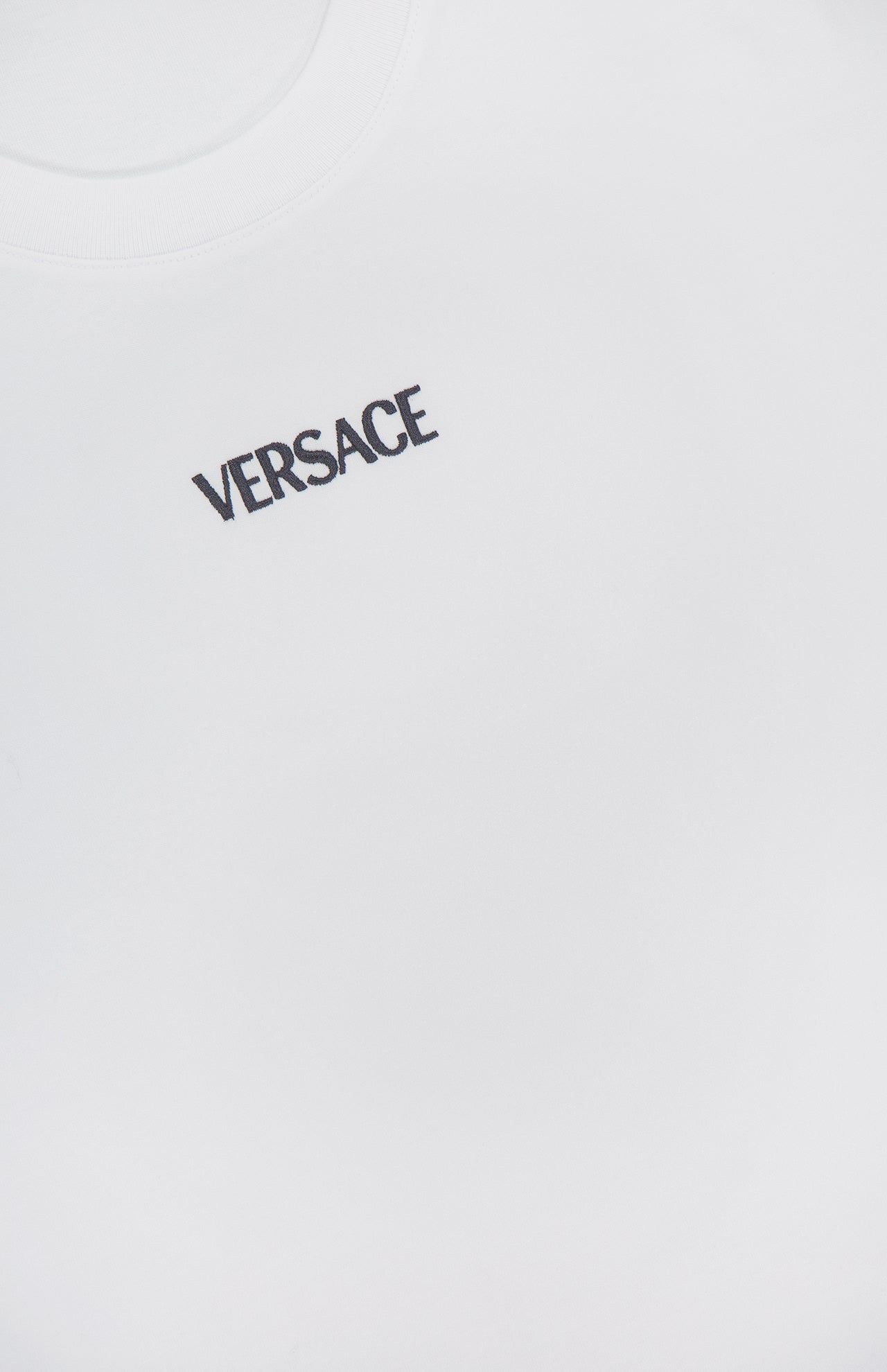 Close-up of the Cotton Jersey Versace Embroidery T-shirt by VERSACE, showcasing the bold embroidered logo on the upper left chest and smooth, premium cotton fabric that highlights luxury Italian style.