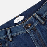 Close-up of the waistband and front pocket on VERSACE Non-Stretch Dirty Wash Jeans in Dirty Blue, showcasing the brand label, button, zipper, and detailed yellow stitching on vintage-effect denim.