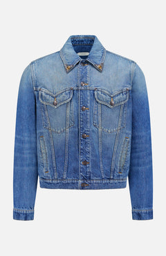 The VERSACE Rigid Stone Washed Denim Jacket features long sleeves, front button closure, Medusa hardware, two chest flap pockets, and side pockets in blue denim, shown against a plain white background.