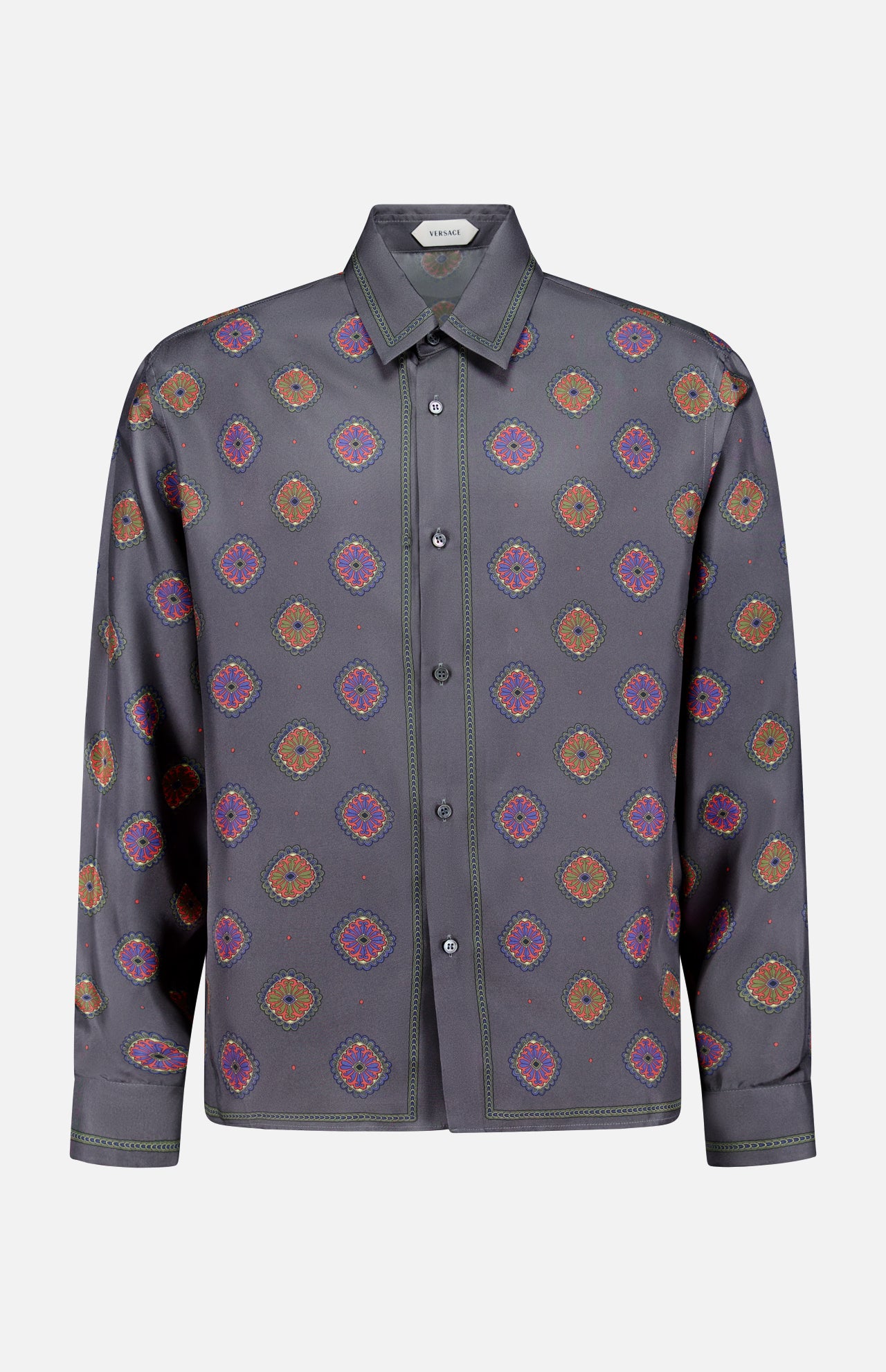 The VERSACE Silk Twill Print The Suitor Shirt is a luxury Italian menswear piece featuring long sleeves, a button-up front, dark gray base, orange, purple and pink geometric print, collar, and visible green edge stitching.