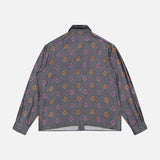 The VERSACE Silk Twill Print The Suitor Shirt is a gray long-sleeve button-up featuring orange, red, and purple geometric motifs. Shown flat from the back, this Italian menswear piece exudes signature luxury.
