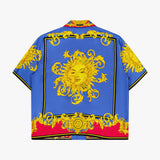The VERSACE Silk Twill Print The Sun Shirt is a short-sleeve button-up featuring bold blue, red, and black Baroque prints, ornate yellow patterns, and a large stylized sun with a face on the back—ideal for luxe Italian style lovers.