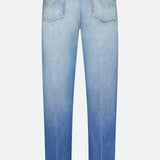 Back view of VERSACE’s Stone Washed Rigid Jeans in light blue, featuring straight-leg design with faded details, two back pockets, and a black leather patch on the waistband, highlighting the refined style of men’s designer denim.