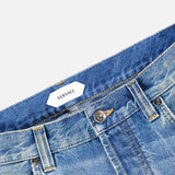 Close-up of light blue VERSACE Stone Washed Rigid Jeans, highlighting the waistband, front button, belt loops, and a glimpse of the signature brand label—an essential detail for those looking for men’s designer jeans in a classic straight-leg fit.