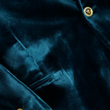 A close-up of the VERSACE Viscose Silk Liquid Velvet Evening Jacket showcases its men’s luxury design in deep green velvet, highlighted by gleaming gold buttons and a welt pocket that emphasize the sumptuous texture and rich, vibrant color of the fabric.