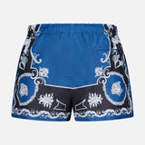 The Mythic Barocco Print Swim Shorts by VERSACE feature a blue and black design with a white baroque pattern, an elastic waistband, and a small right-side pocket, inspired by luxury Italian swimwear.