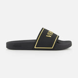 The Rubber + Embossing Versace Slide Sandals by VERSACE feature a wide black strap with gold trim and bold branding, minimalist design, and flat sole, elegantly displayed from the side against a white background.