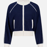 The WHITE + WARREN Cashmere Blend Track Jacket is shown on a plain background, featuring a navy design with white trim, a high collar, white ribbed cuffs and hem, and distinctive white vertical stripes along the sleeves and pockets.