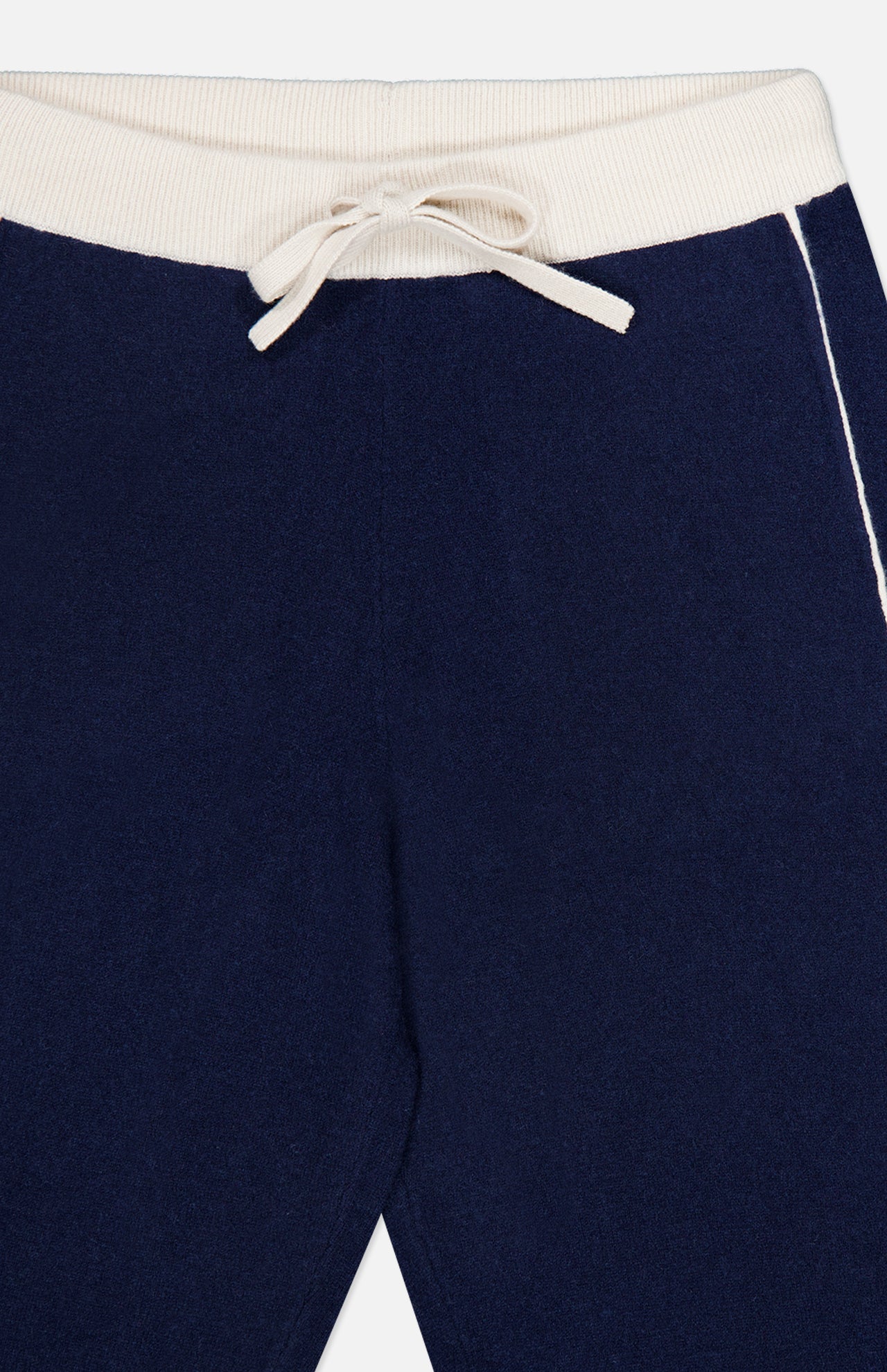 Close-up of the WHITE + WARREN Cashmere Blend Track Pants in navy, featuring a white ribbed waistband, drawstring waist, and a thin white stripe running down the side—perfect knit bottoms for both comfort and style.