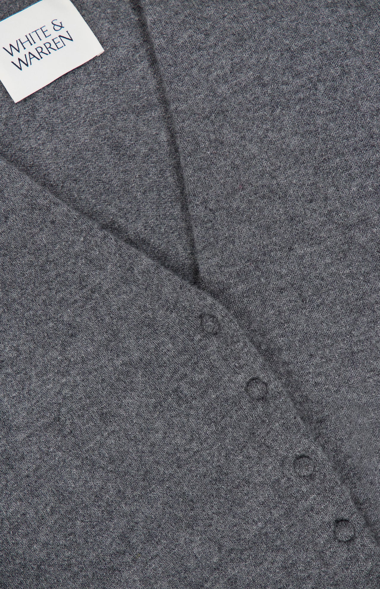 Close-up of the WHITE + WARREN Cashmere Deep V-neck Cardigan in gray. Four small buttons line a pointed seam, indicating this is a button-up cardigan. The fabric looks soft and slightly textured, highlighting the luxurious quality of its cashmere construction.