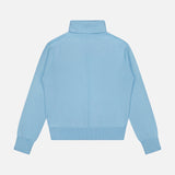The Cashmere Rib Trim Easy Turtleneck Sweater by WHITE + WARREN is shown from the back in light blue, featuring a high turtleneck collar, ribbed cuffs, and waistband against a plain white background.