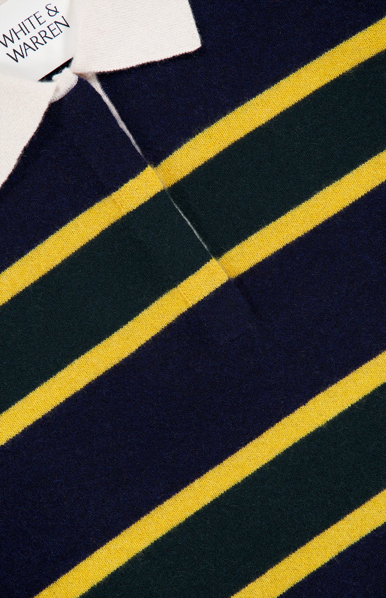 Close-up of the WHITE + WARREN Cashmere Rugby Long Sleeve Polo Shirt, featuring navy blue, green, and yellow horizontal stripes and a white rugby-style collar, with the WHITE + WARREN label visible.