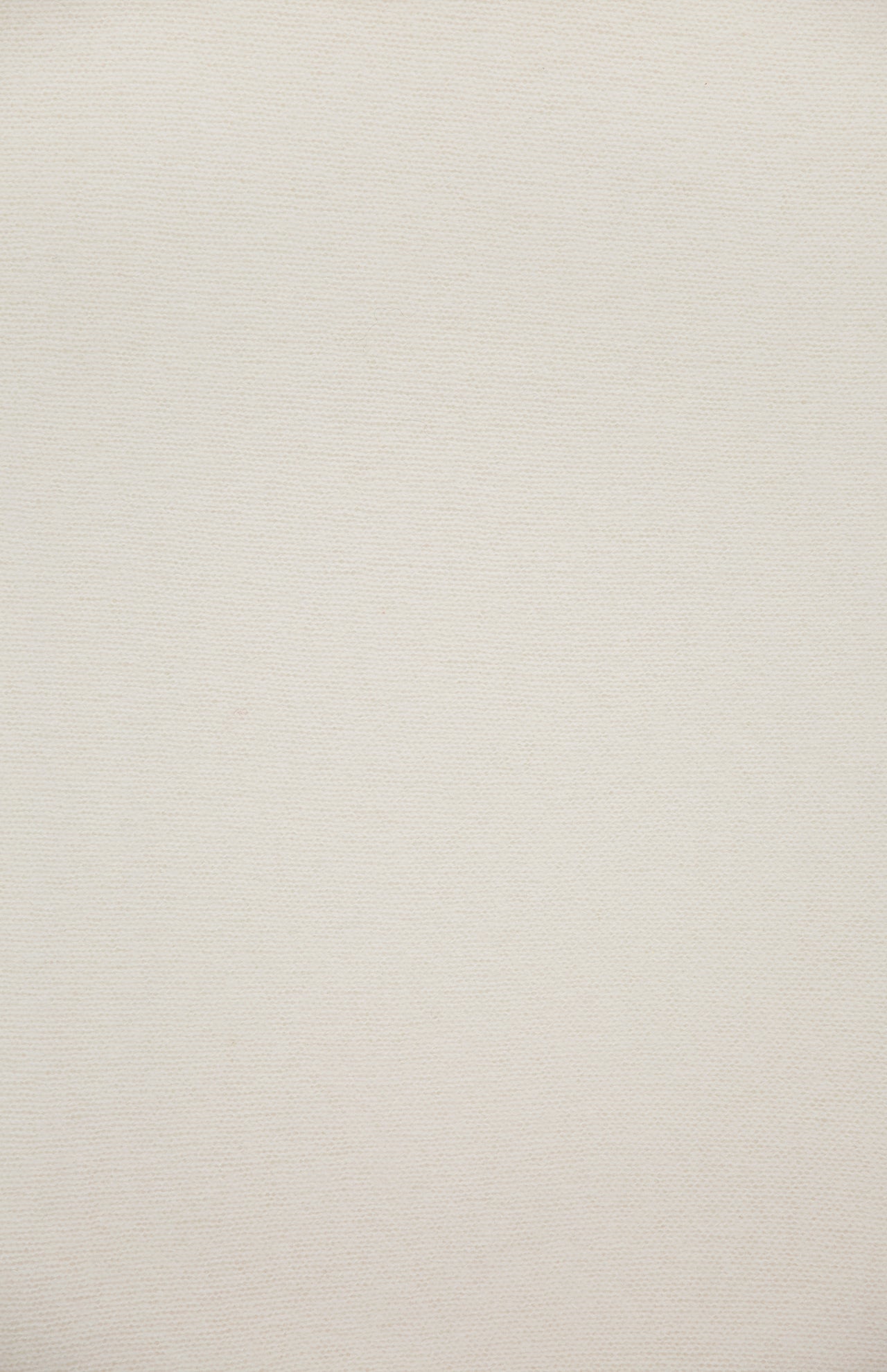 A close-up of a plain, off-white textured surface, likely the WHITE + WARREN Cashmere Travel Wrap, with no visible patterns or distinguishable features.