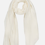 A WHITE + WARREN Cashmere Travel Wrap in a lightweight, off-white hue is loosely folded on a plain white background, highlighting the luxurious comfort of this cashmere accessory.