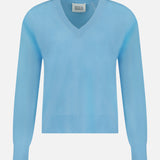 The WHITE + WARREN Cashmere V-neck Sweater is shown in light blue, featuring long sleeves with ribbed cuffs and hem, displayed against a plain white background. This sweater offers luxurious softness and classic style, making it a timeless addition to your wardrobe.