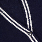 Close-up of the WHITE + WARREN Cashmere Varsity Cardigan in navy, featuring white double stripes on the V-neckline and button placket, dark buttons, and a visible WHITE + WARREN label in the top left corner.
