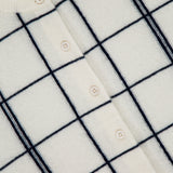 Close-up of the WHITE + WARREN Cashmere Windowpane Cardigan Sweater in off-white, showcasing a black windowpane pattern and front button closure. The collar label displays "WHITE + WARREN.