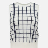The WHITE + WARREN Cashmere Windowpane Vest is a sleeveless, off-white sweater vest detailed with a black windowpane pattern of bold horizontal and vertical lines. It features ribbed finishes at the neckline, armholes, and hem.