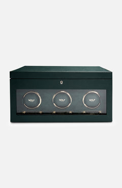 The WOLF British Racing Triple Watch Winder features a green rectangular design with a glass front that showcases three circular compartments, each marked with the WOLF logo. Crafted from premium vegan leather for an elegant and sustainable exterior, this watch winder is designed to wind automatic watches while offering sophisticated storage.
