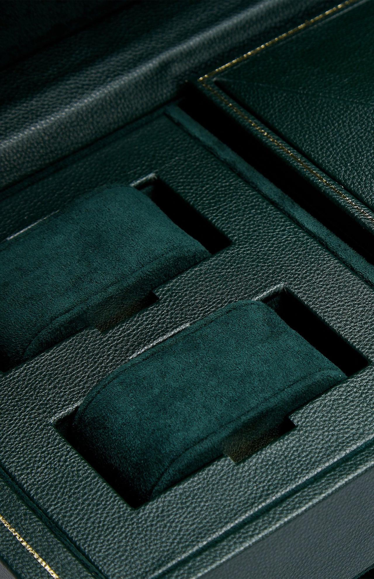 Close-up of the WOLF British Racing Triple Watch Winder’s luxurious green vegan leather interior, featuring two padded watch holders. Each holder is wrapped in soft, green suede and fits securely within its own compartment, offering an elegant and sophisticated solution for watch storage.