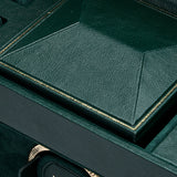 Close-up of the WOLF British Racing Triple Watch Winder—a luxurious green watch storage box crafted from vegan leather, featuring a geometric lid, gold trim, and an interior compartment with the WOLF label.