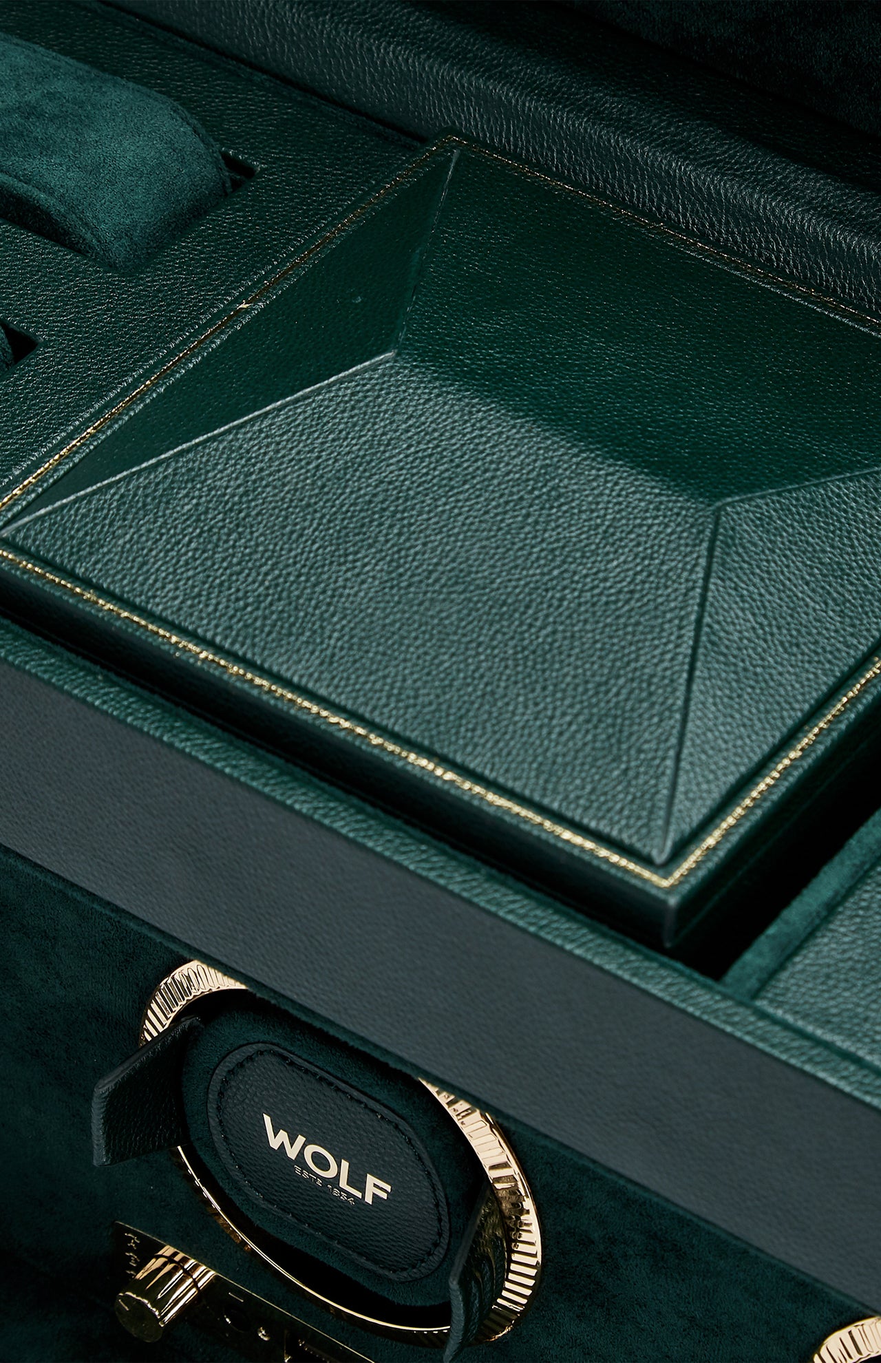 Close-up of the WOLF British Racing Triple Watch Winder—a luxurious green watch storage box crafted from vegan leather, featuring a geometric lid, gold trim, and an interior compartment with the WOLF label.