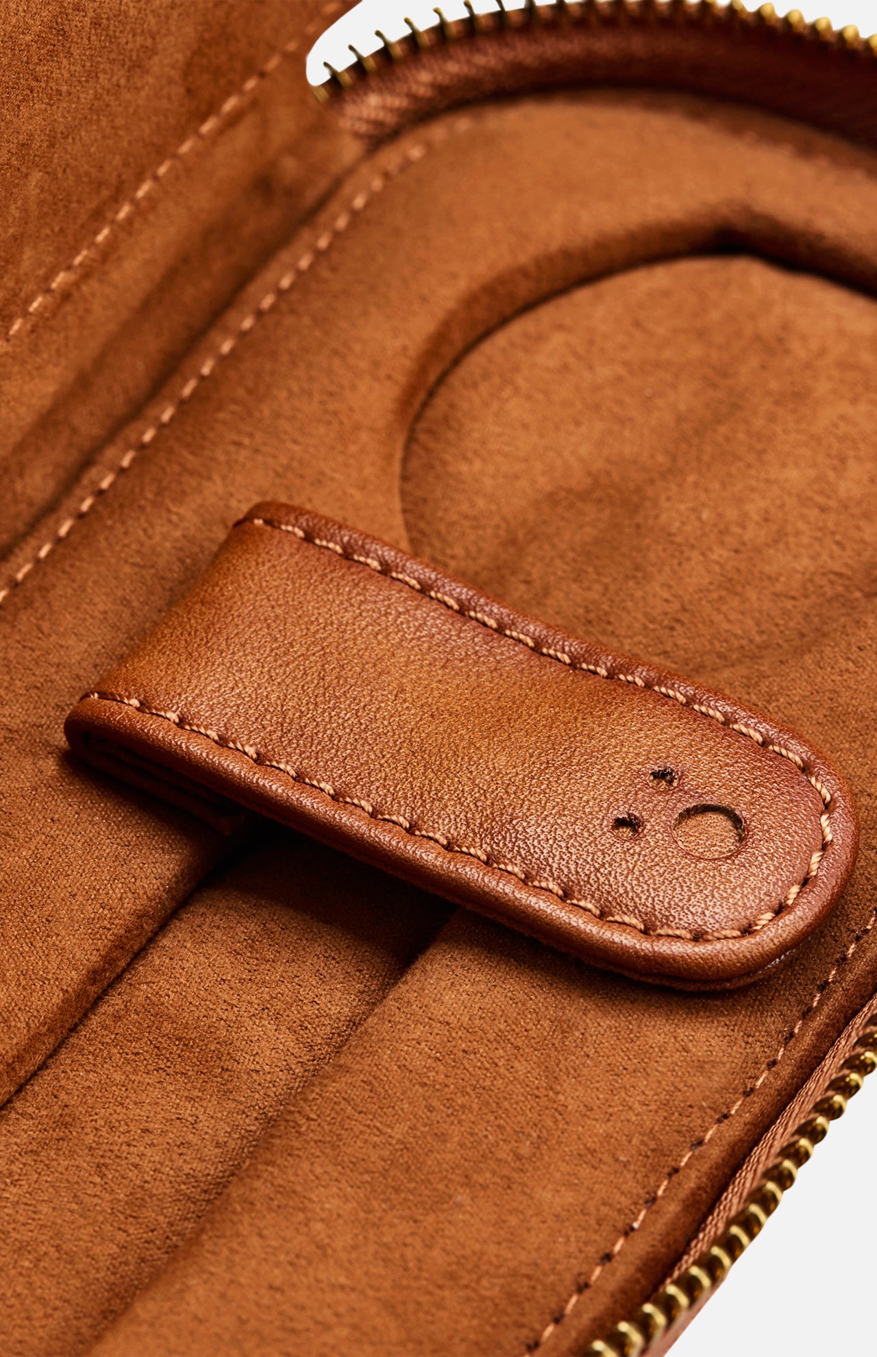Close-up of the WOLF Brogue 2 Piece Watch Zip Case in brown leather, showcasing visible stitching and a snap closure. The case is open to display its interior compartment and zippered edge, evoking the elegance of a refined watch holder crafted for luxury timepiece storage.