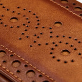 Close-up of brown leather with decorative perforated patterns and stitching on the WOLF Brogue 2 Piece Watch Zip Case, highlighting its refined craftsmanship and design.