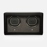 A black rectangular Cub Double Winder with Cover by WOLF, crafted from premium vegan leather, features two circular slots with the WOLF logo displayed on each, a glass front panel, and is photographed against a plain white background. This luxurious design keeps your timepieces flawlessly wound.