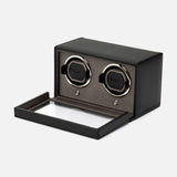 Introducing the WOLF Cub Double Winder with Cover—a black watch winder box crafted from premium vegan leather, featuring a glass front panel that opens to reveal two watch holders inside. Designed to complement luxury timepieces, it exudes an exquisite touch and is showcased here against a white background.