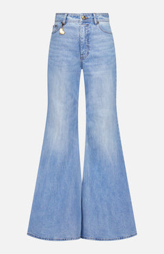 The Bonus Charm Flare Jean by ZIMMERMANN features a vintage blue wash, high-rise fit, dramatic flared leg, and button-zip closure, shown against a white background.