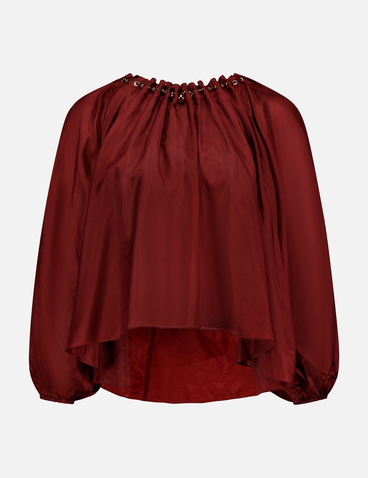 The ZIMMERMANN Aster Gathered Bead Blouse is a loose-fitting, long-sleeve bohemian top in dark red, featuring a grommet-detailed neckline and flowy asymmetrical hem, shown against a plain white background.