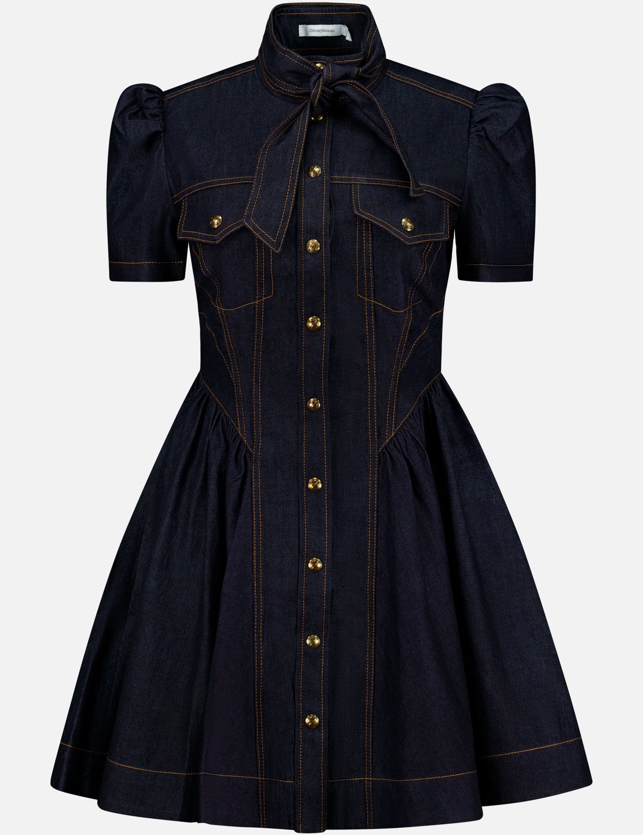 Introducing the ZIMMERMANN Denim Corset Mini Dress: a short-sleeve dark denim mini dress featuring a flared skirt, puffed shoulders, and distinctive gold buttons down the front. Designed with two chest pockets and a tied neck bow, this dress stands out with orange stitching accents along the seams and details. Subtle corset-style shaping offers a flattering silhouette.