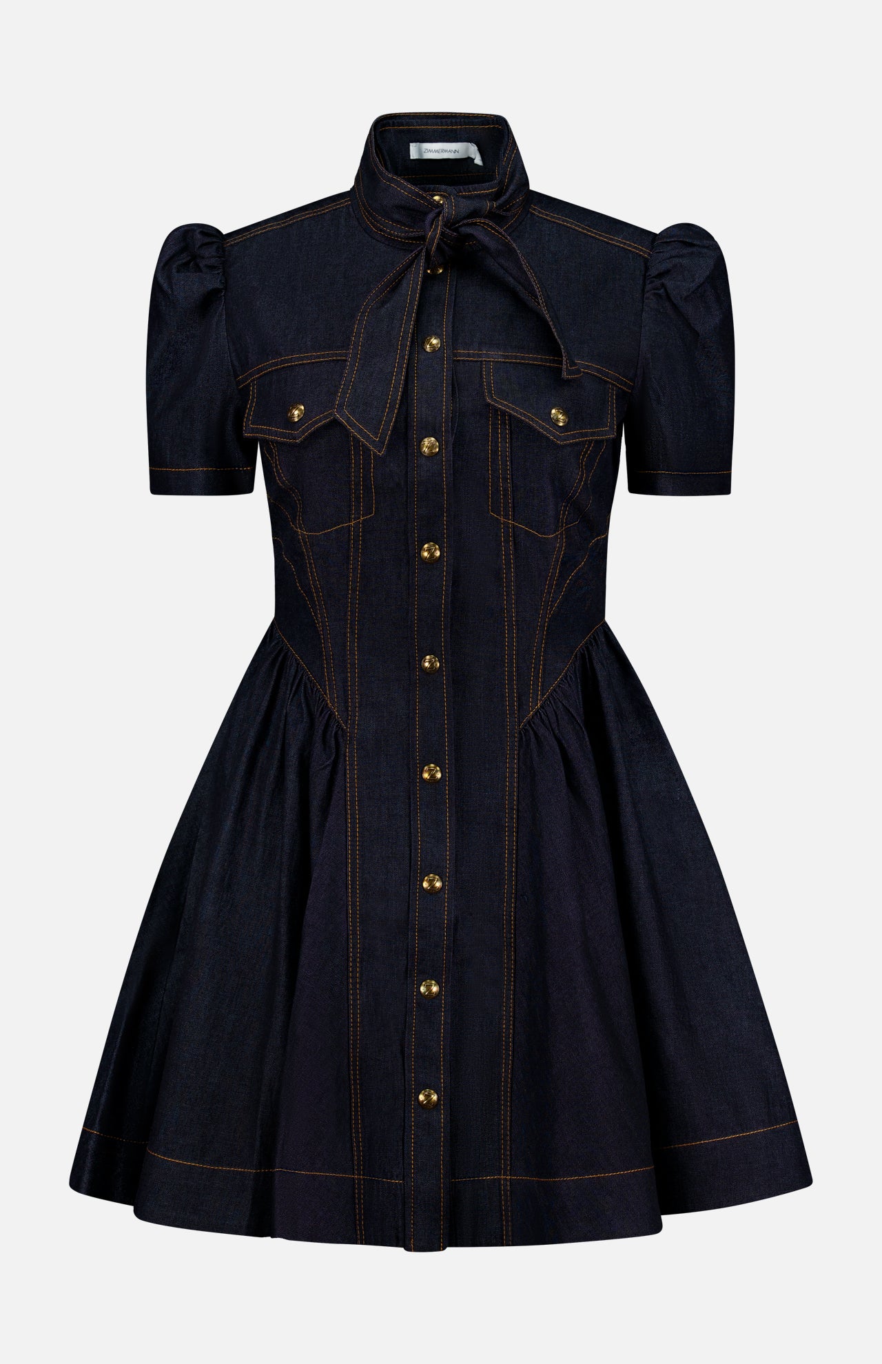 Introducing the ZIMMERMANN Denim Corset Mini Dress: a short-sleeve dark denim mini dress featuring a flared skirt, puffed shoulders, and distinctive gold buttons down the front. Designed with two chest pockets and a tied neck bow, this dress stands out with orange stitching accents along the seams and details. Subtle corset-style shaping offers a flattering silhouette.