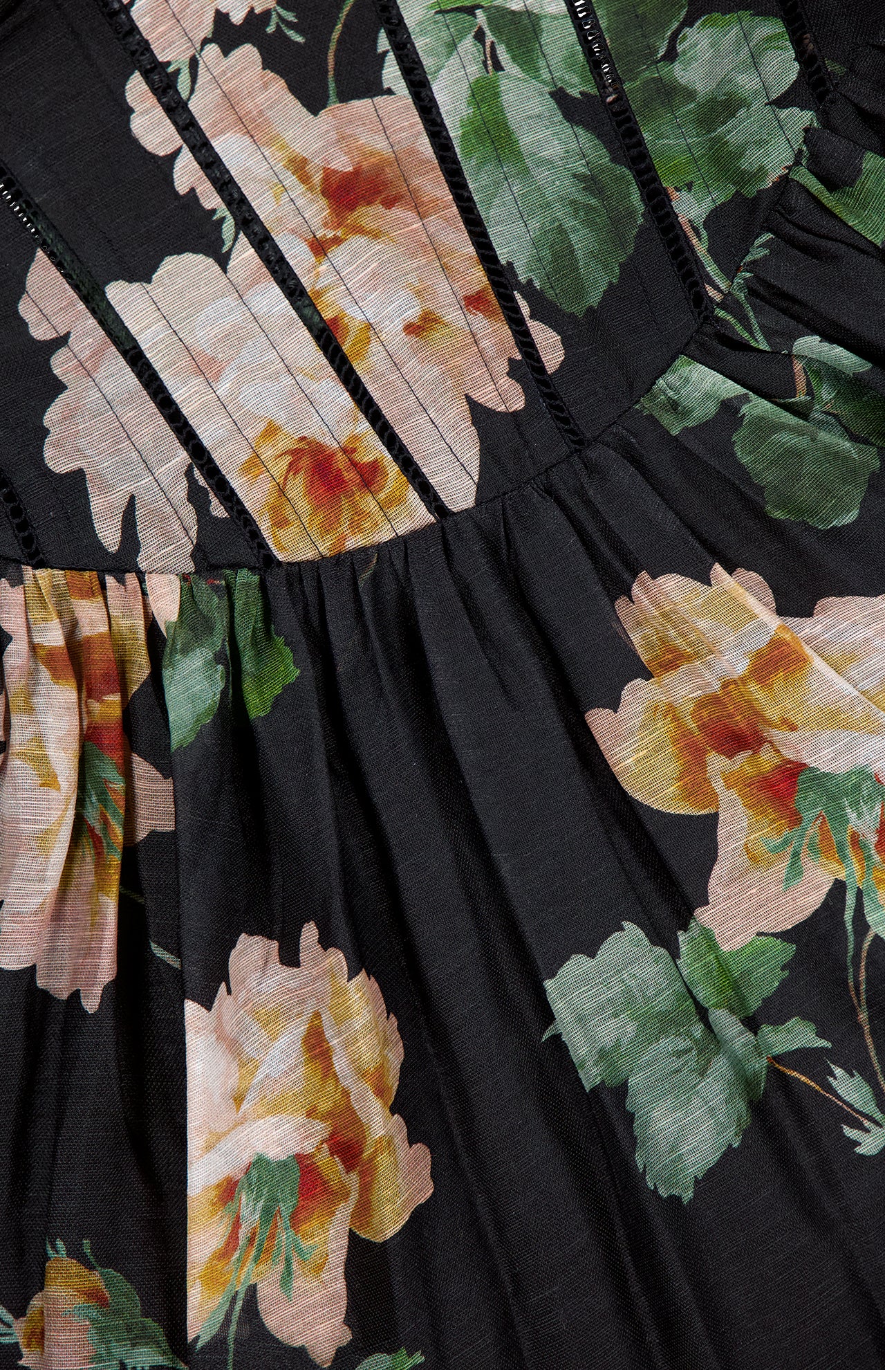 Close-up of the Luna Corset Midi Dress by ZIMMERMANN, a black midi dress with large peach floral prints, green leaves, and narrow vertical seams that give it a corset-inspired look.