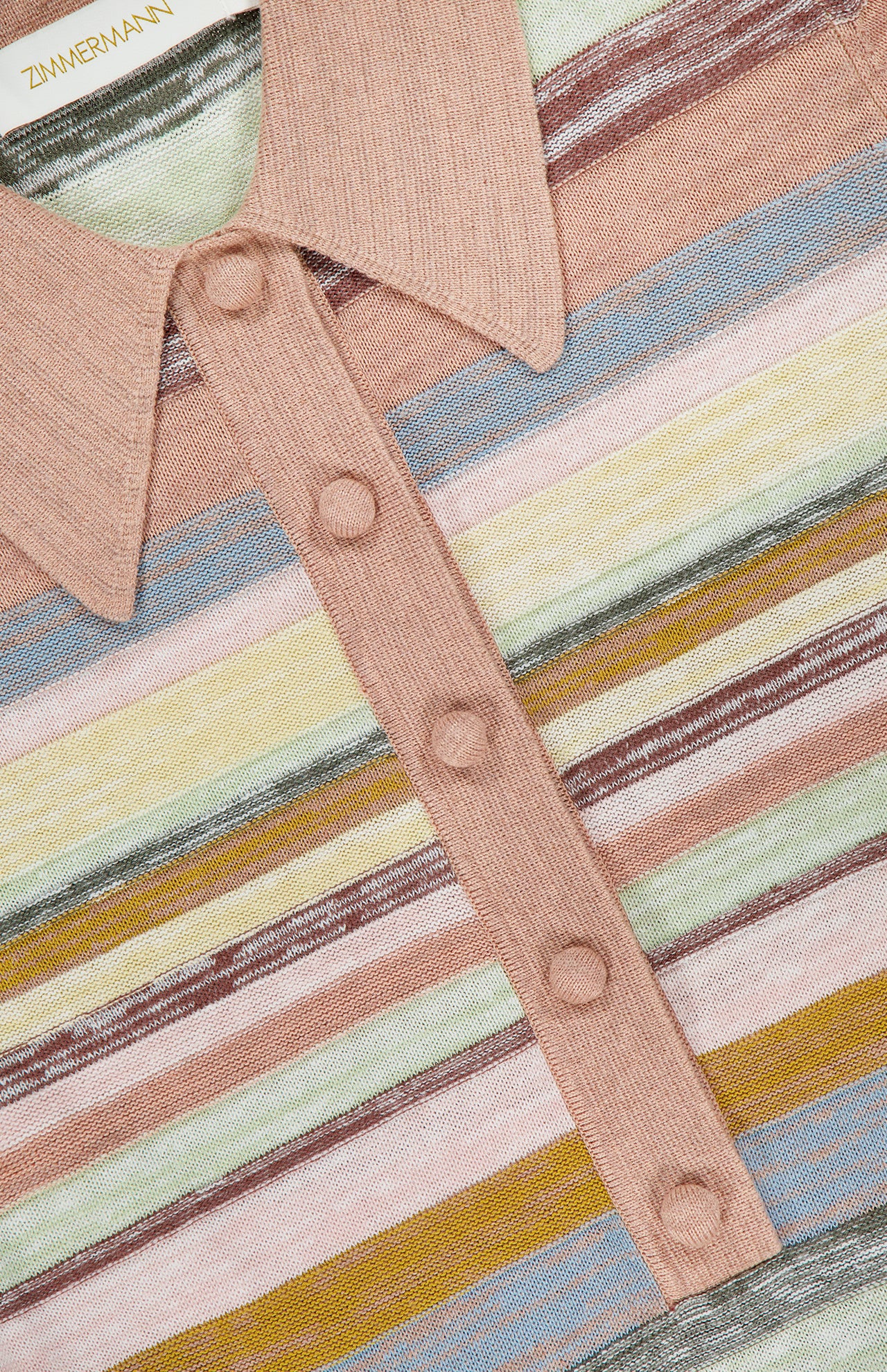 Close-up of the ZIMMERMANN Luna Mouline Polo Midi Dress in a cotton-linen blend with fabric-covered buttons and pastel pink, green, blue, and yellow horizontal stripes. The inner label shows ZIMMERMANN.